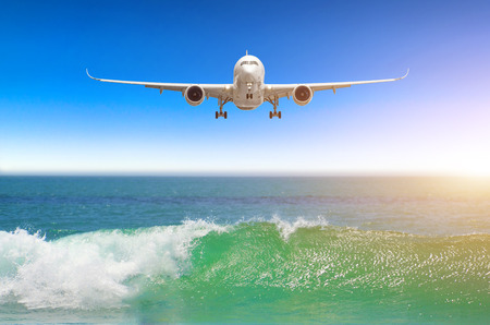 Airplane flying over amazing ocean landscape with tropical island, travel destinationsの写真素材