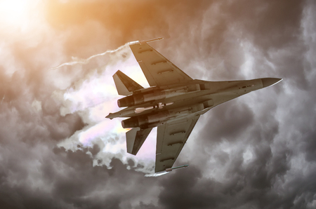 Battle fighter jet flying dives breaking clouds on a thunderstorm skyの写真素材