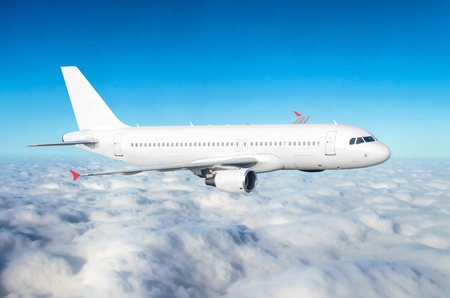 Passenger plane fly on a train above clouds and blue skyの写真素材