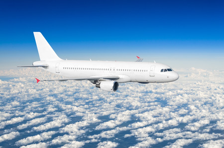 Passenger plane fly on a train above clouds and blue skyの写真素材