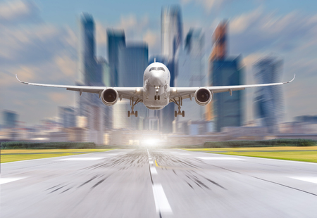 Airplane at the airport take off against the background of the city and skyscrapersの写真素材