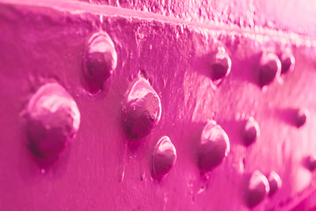 Pink paint on metal rivets close upの写真素材