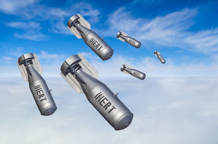 Falling bombs weapons charges dropped from a fighter combat aircraft high in the sky, a view of clouds and landの写真素材