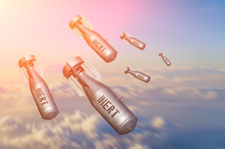 Falling bombs weapons charges dropped from a fighter combat aircraft high in the sky, a view of clouds and landの写真素材