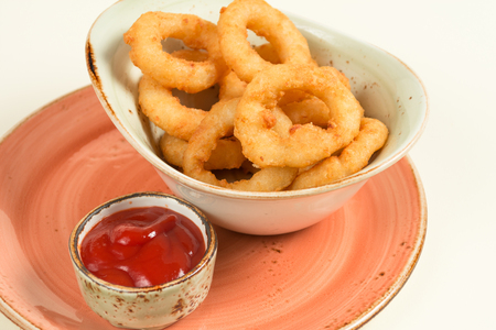 Garlic rings in the deepest part and ketchup on a platterの写真素材