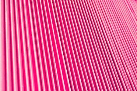 Abstract background of vertical relief metal ribs covered with glamorous pink colorの写真素材