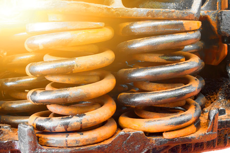 Huge steel spring shock absorbers black and rusty close upの写真素材