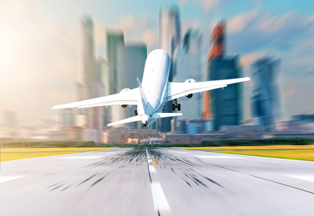 Airplane back view at the airport take off against the background of the city and skyscrapersの写真素材