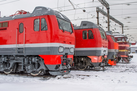 Electric locomotives are lined up on the railway in winter snow depotの写真素材