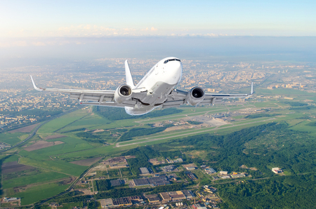 Airplane is climb flight level high view in the air, against the background sky horizon the airport of the runway, city, fields, forests and roadsの写真素材