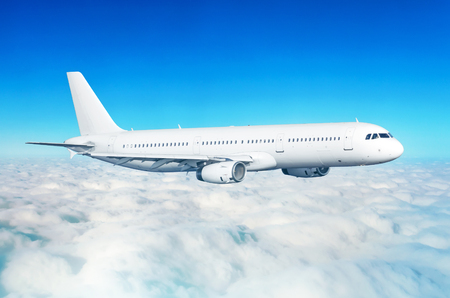 Passenger airplane fly on a hight above overcast clouds and blue skyの写真素材