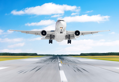 Big airplane aircraft flying departure landing speed motion on a runway in the good weather with cumulus clouds sky dayの写真素材