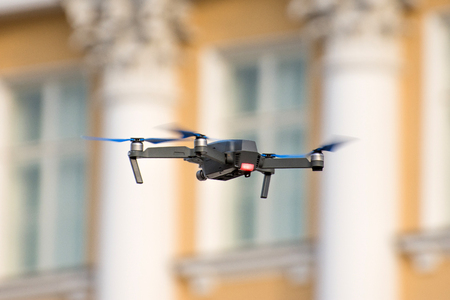 Drone quad copter is flying against the background of windows and columns of an ancient buildingの写真素材