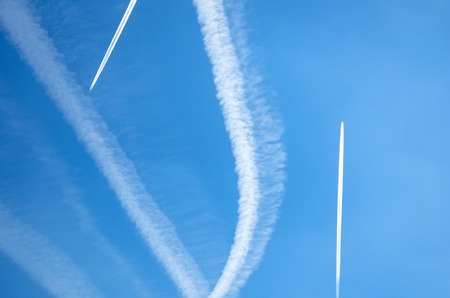 Contrails from airplanes high in the blue skyの写真素材