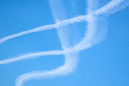 Contrails from airplanes high in the blue skyの写真素材