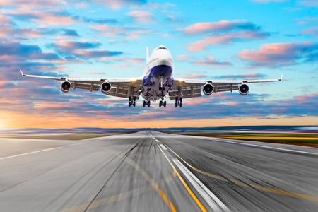 Wing view runway at the airport sky and a airplane taking off in the distanceの写真素材