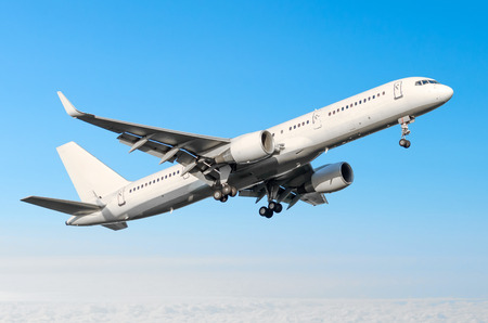 Airplane ready for landing flying in the blue sky with landing gear and flapsの写真素材
