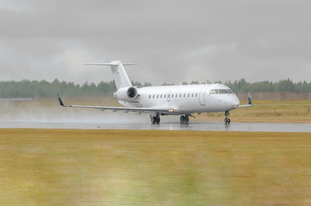 Small Airplane landing in a wet runway during the rain at the airportの写真素材