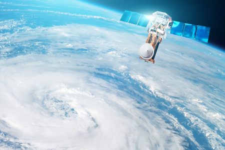 Research, probing, monitoring of tracking in a tropical storm zone, a hurricane. Satellite above the Earth makes measurements of the weather parameters.の写真素材