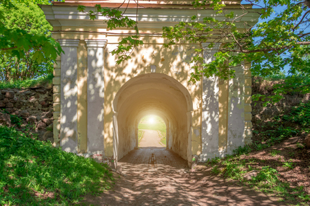 Architectural stone arch in the forest and light at the end of the tunnelの写真素材