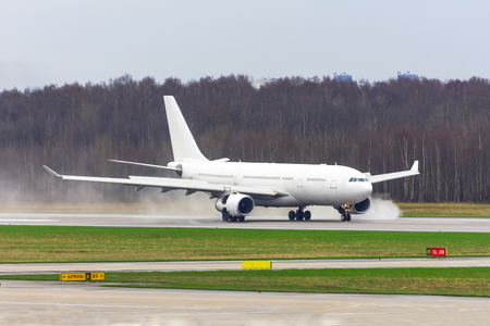 Airplane landed on a wet runway at the airportの写真素材