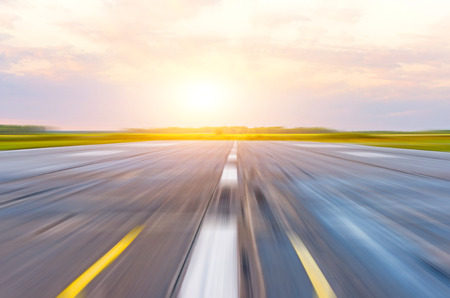 Runway at the airport in the morning at dawn sunset sun light motion blurの写真素材