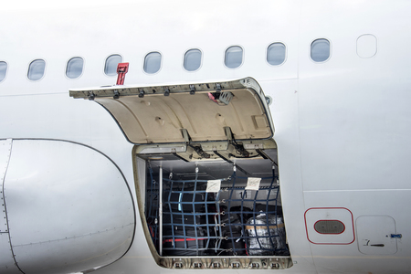 Luggage compartment and cargo section in the airplane open on inspection, with bags and luggage of passengersの写真素材