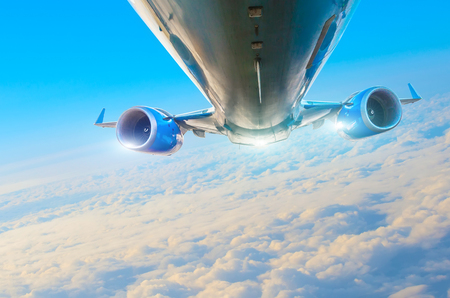 Passenger airplane fly on a hight above overcast clouds and blue skyの写真素材