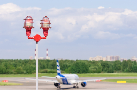 Red warning warning light with the light on, against the blue sky. Close up aircraft warning light on top of a highrise of building airport. for safety conceptの写真素材