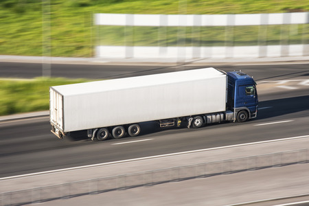Large truck with a trailer on the highway at a speed that moves along the asphalt, view from aboveの写真素材
