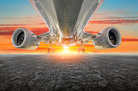 Airplane in the parking lot of the airport apron, bottom view- engines, fuselage and wings. Background of the sky sunset sky cloudsの写真素材