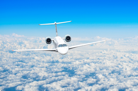 Small passenger plane flies in the sky above the cloudsの写真素材