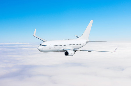 Airplane flies climbs height, flight level high in the sky above the clouds blue skyの写真素材
