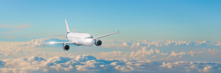 Passenger aircraft cloudscape with white airplane is flying in the evening sky cumulus clouds, panorama viewの写真素材
