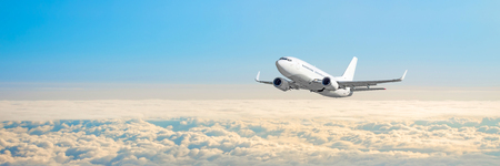Passenger aircraft cloudscape with white airplane is flying in the daytime sky overcast, panorama viewの写真素材