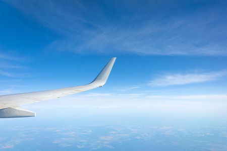 Wing view of the airplane on a winglets, clouds on the skyline during climbing flight levelの写真素材