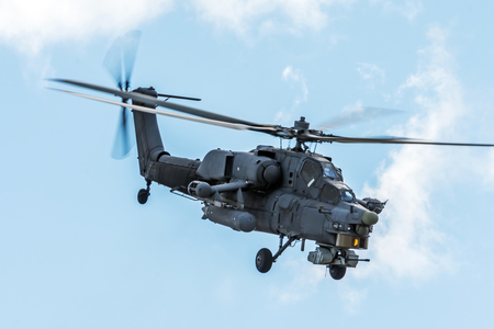 Military helicopter in the sky on a combat mission with weaponsの写真素材