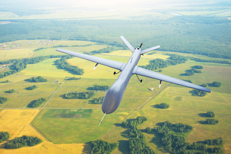 Patrolling unmanned aircraft in the sky above the terrain, fly trackingの写真素材