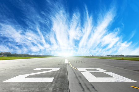 Airport runway to in horizon and picturesque cirrus clouds in the blue skyの写真素材