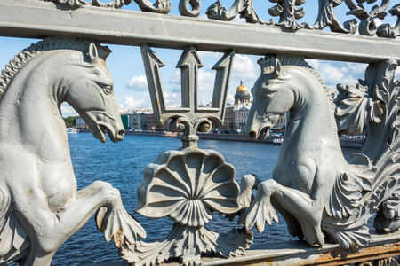 Metal bridge with a forge with forged patterns of horses and tridents in the background Isaak's Cathedralの写真素材