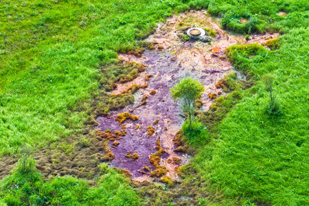 Emission of pollution by sewage from the city of the hatch on the lawn with green grassの写真素材