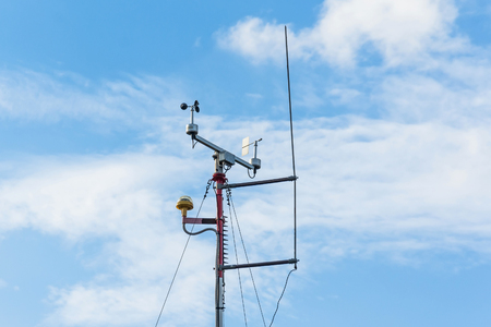 Automatic weather station, with a weather monitoring system. Against the background of a blue sky with cloudsの写真素材