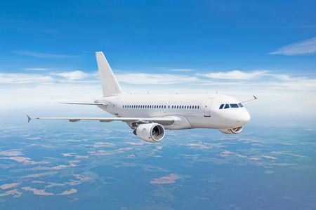 Passenger airplane fly on a hight above clouds and blue skyの写真素材