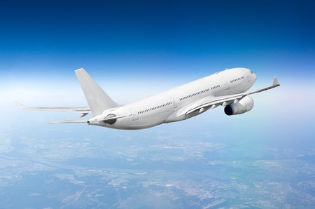 Flying airplane above the clouds horizon skyの写真素材