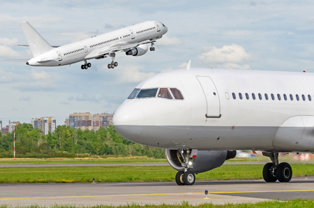 Flying take off plane and another airplane taxiingの写真素材