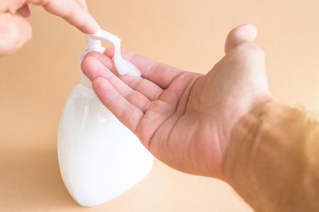 Liquid soap bottle and pressing on the dispenser, soap on the palm. Washing handsの写真素材