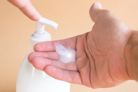 Liquid soap bottle and pressing on the dispenser, soap on the palm. Washing handsの写真素材
