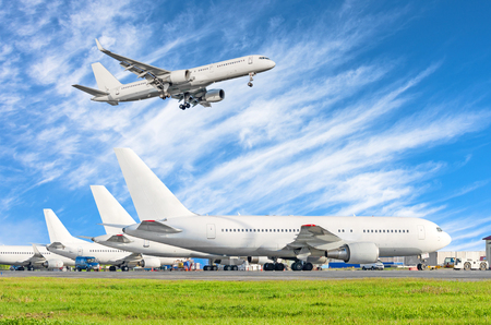 Airport and three planes on earth, in the sky approach landing aircraftの写真素材
