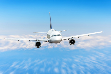 Airplane in the sky above the clouds flight journey sun height speed motion blur. Passenger commercial aircraftの写真素材