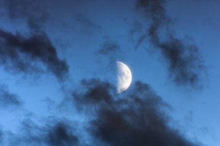 Half moon in the evening in dark clouds